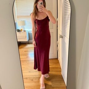 Reformation Aribella ruffled dress in presented in a wine-red wine hue.